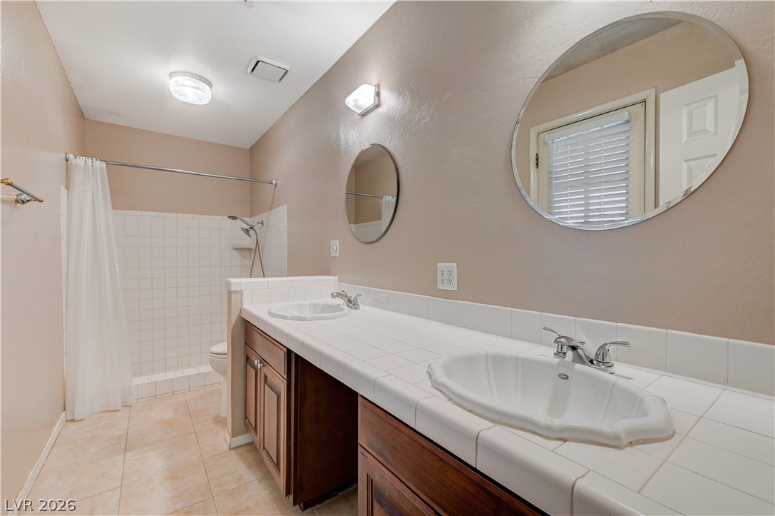 7631 Bermuda Road Las Vegas, NV 89123 - Photo 23 of 64 Double vanity with ample counter space and a tiled walk-in shower.