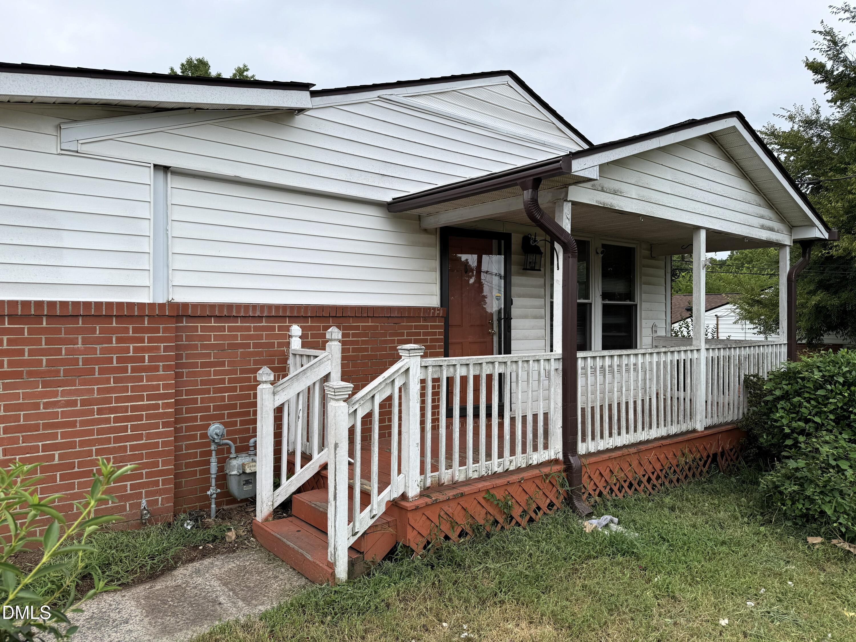 Front exterior featuring a covered porch, white siding, and a brick foundation