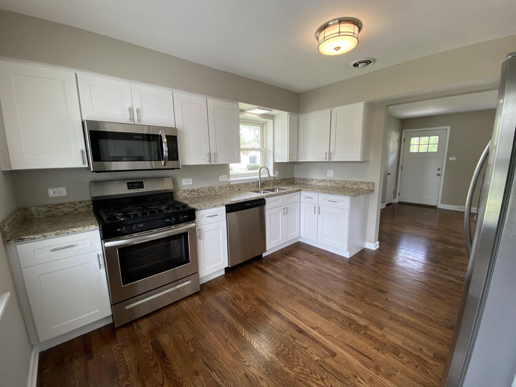 201 Pine Street Villa Park, IL 60181 - Photo 5 of 17 a kitchen with granite countertop a stove a microwave a sink and cabinets