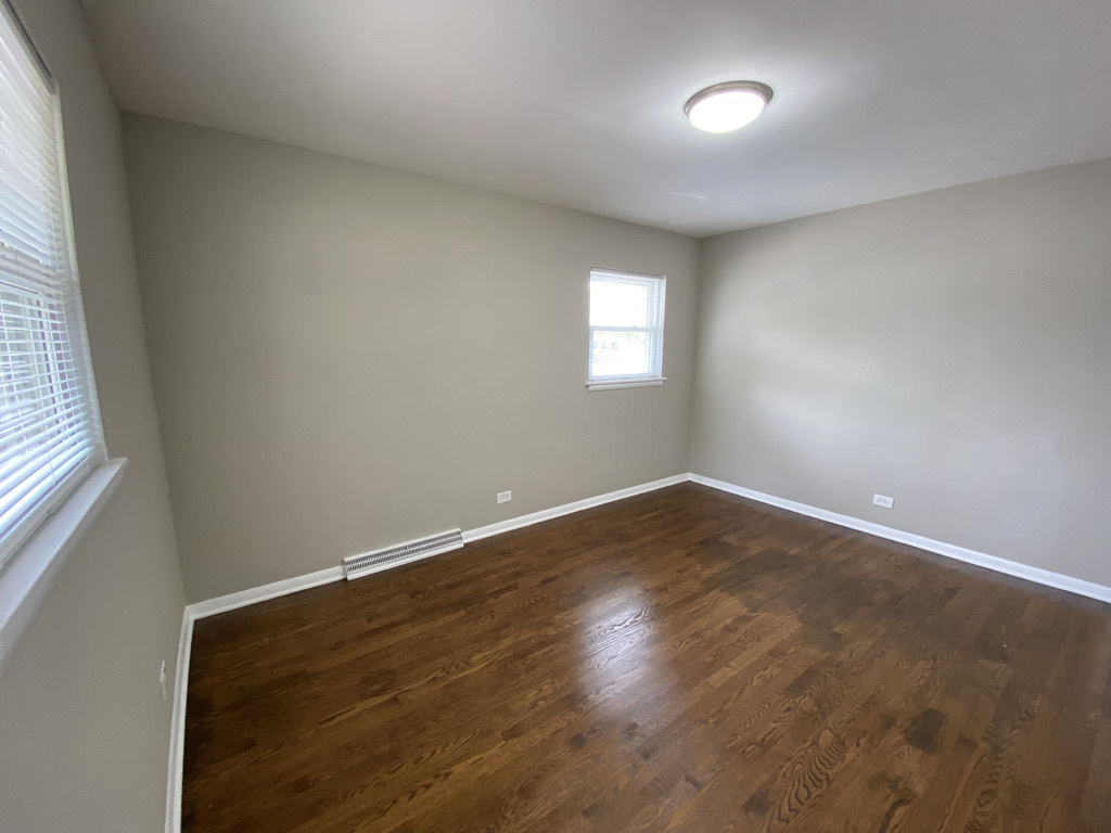 201 Pine Street Villa Park, IL 60181 - Photo 7 of 17 an empty room with wooden floor and windows