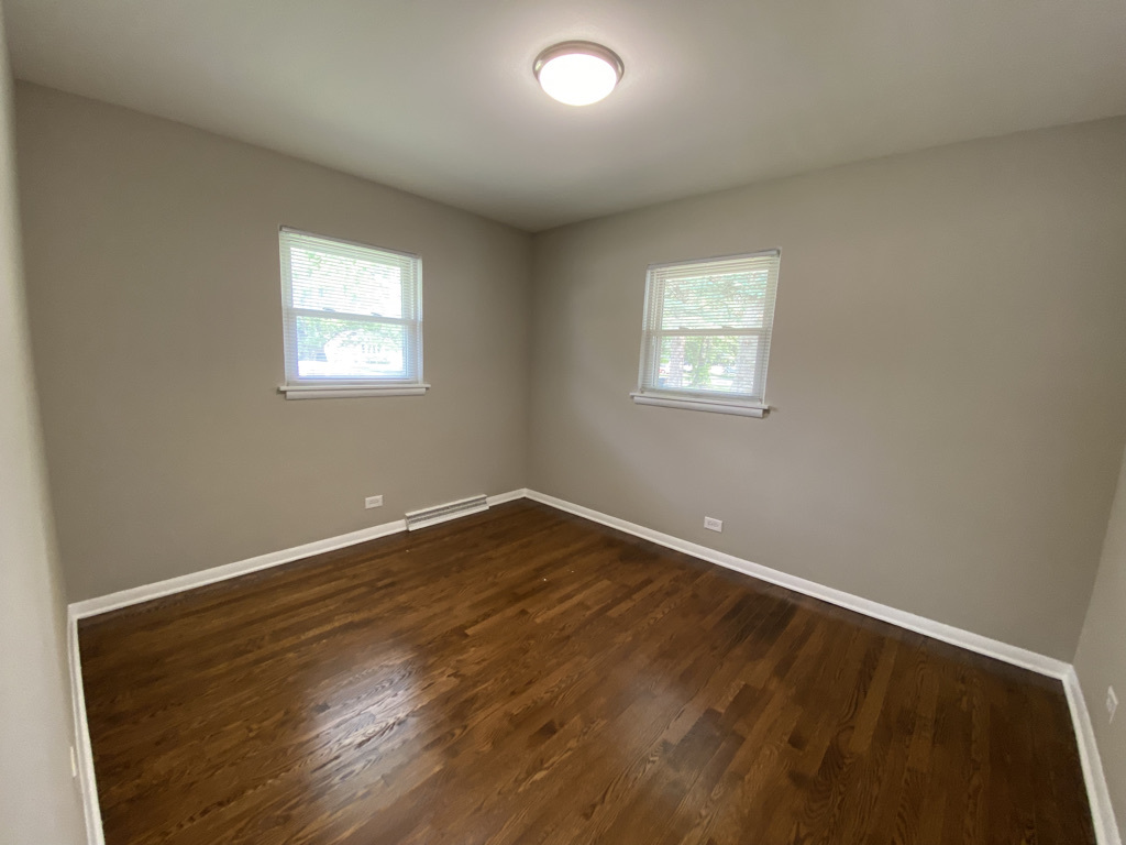 201 Pine Street Villa Park, IL 60181 - Photo 9 of 17 an empty room with wooden floor and windows