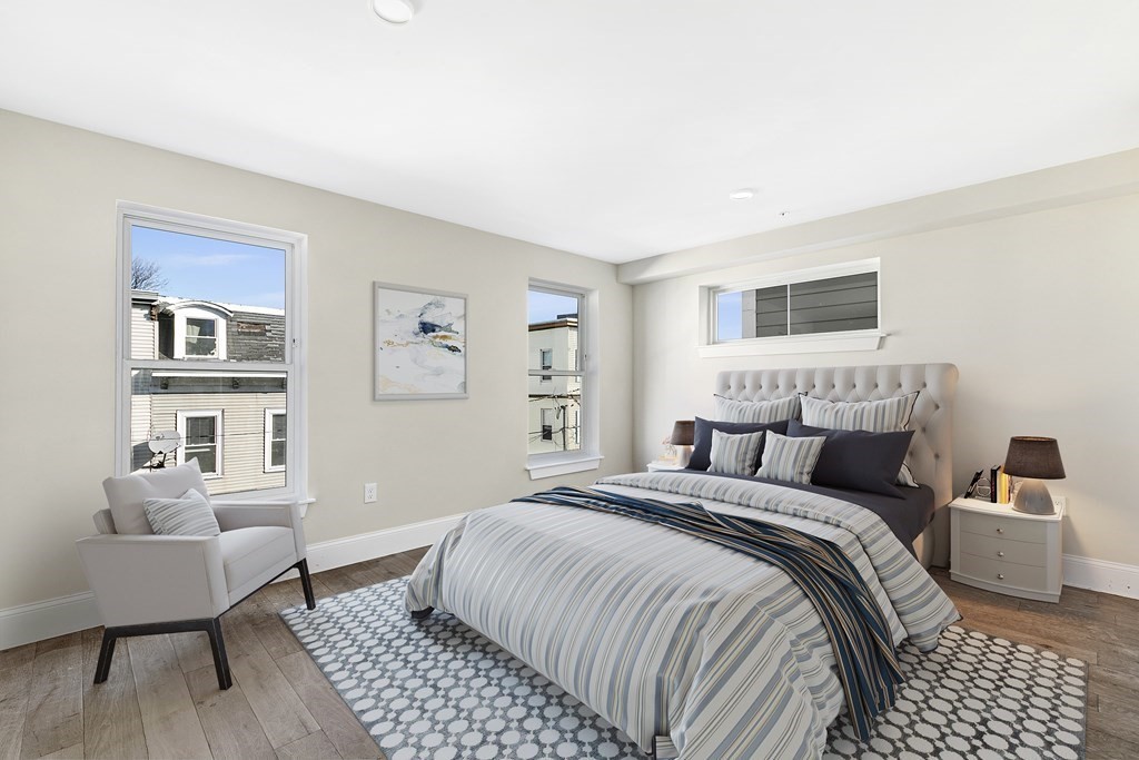 a bedroom with a large bed a couch and a window