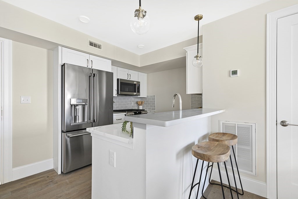 29 Ward Street, Unit 101 Boston, MA 02127 - Photo 5 of 11 a kitchen with stainless steel appliances a refrigerator and a stove
