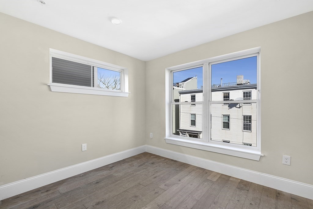 29 Ward Street, Unit 101 Boston, MA 02127 - Photo 10 of 11 a view of an empty room with a window and wooden floor