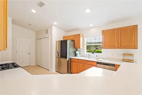 a kitchen with stainless steel appliances granite countertop a sink and a refrigerator