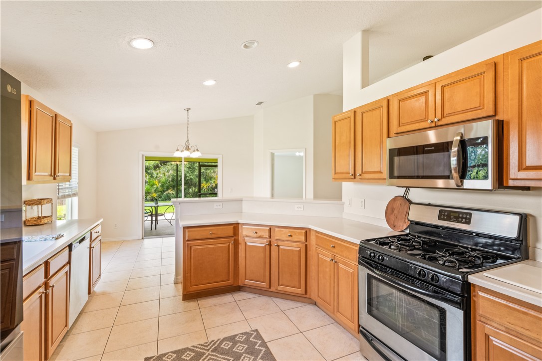 1087 4th Lane Southwest Vero Beach, FL 32962 - Photo 15 of 34 a kitchen with stainless steel appliances granite countertop a stove a sink and a microwave