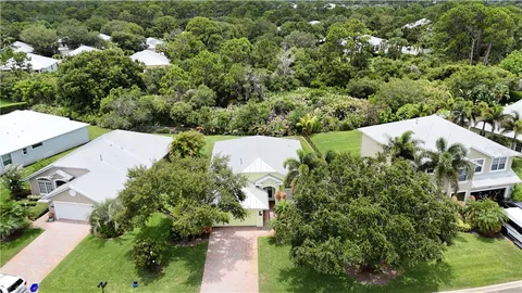 an aerial view of a house with a yard and outdoor seating