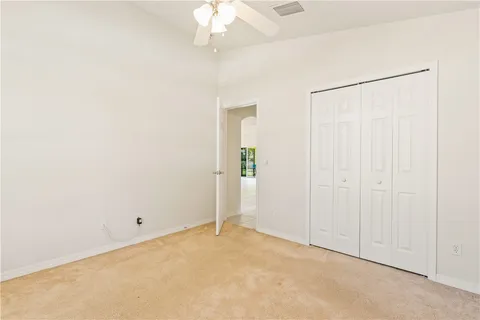 an empty room with a chandelier fan