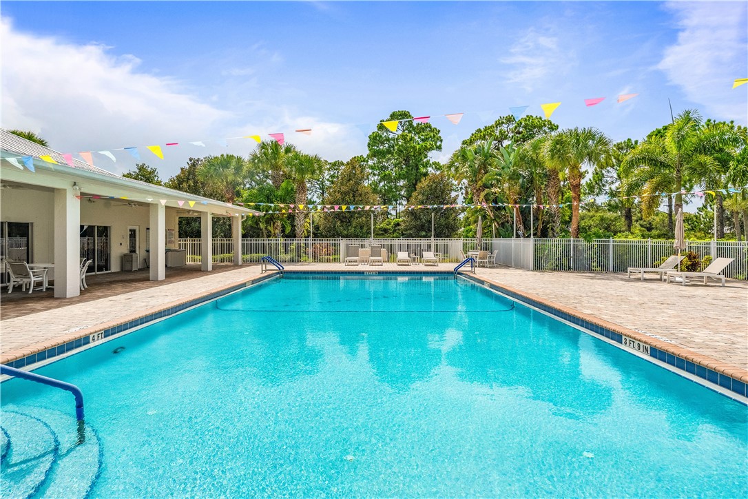 1087 4th Lane Southwest Vero Beach, FL 32962 - Photo 30 of 34 a view of a swimming pool with an outdoor seating and house in the background