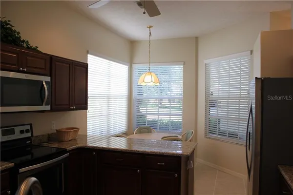 a kitchen with stainless steel appliances granite countertop a refrigerator a sink a stove and island