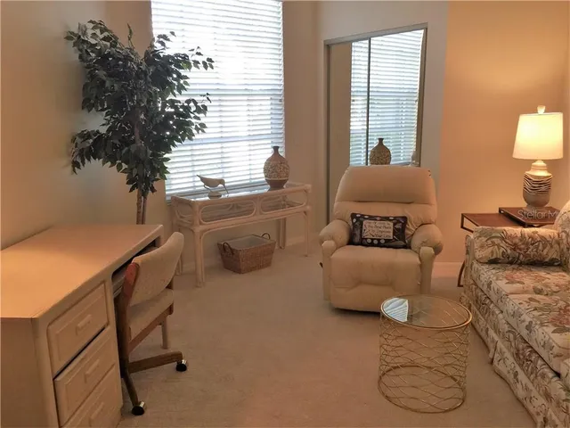 a bed sitting in a bedroom next to a window and a lamp