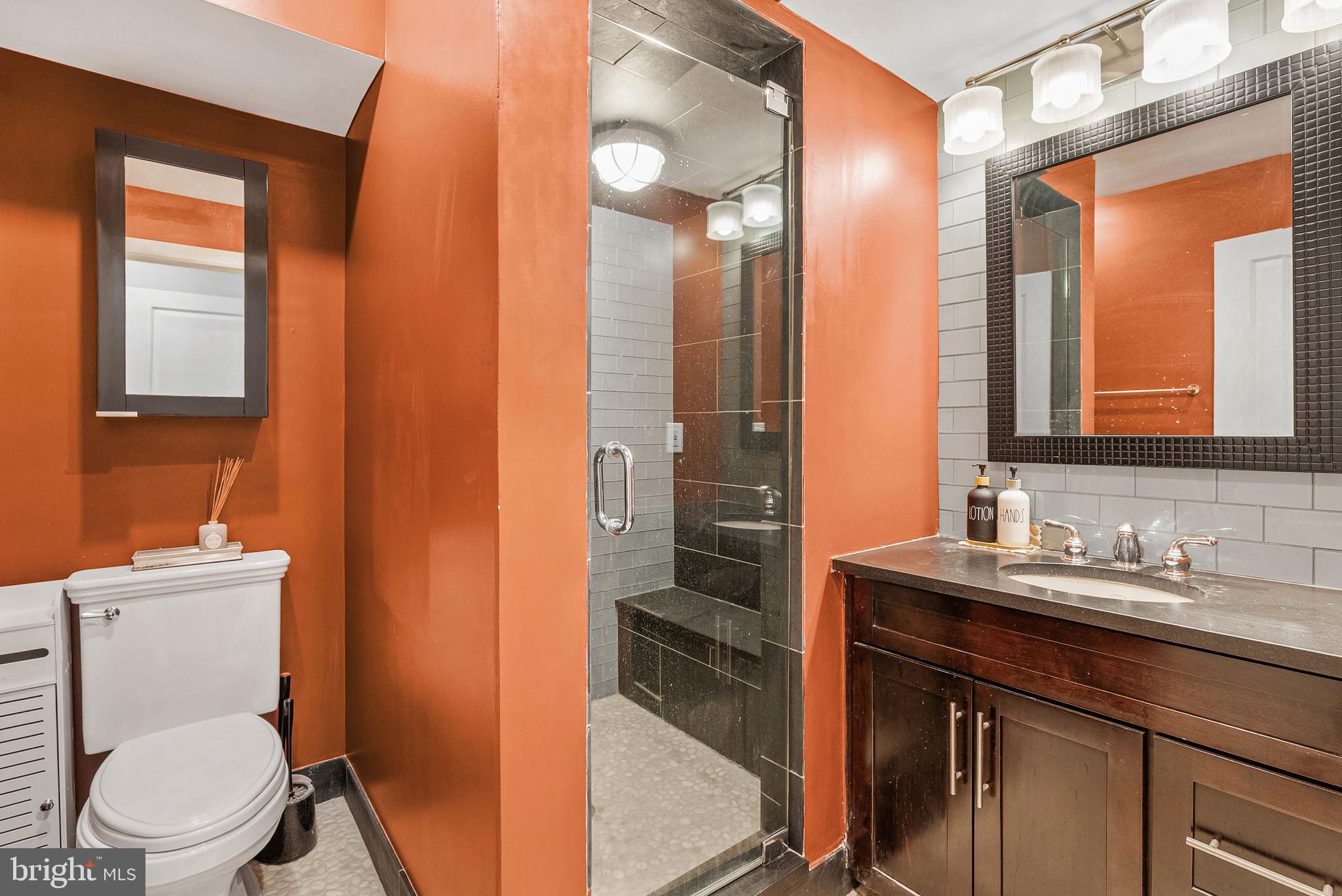 1522 Race Street, Unit 1 Philadelphia, PA 19102 - Photo 12 of 26 a bathroom with a toilet a sink a mirror and a shower