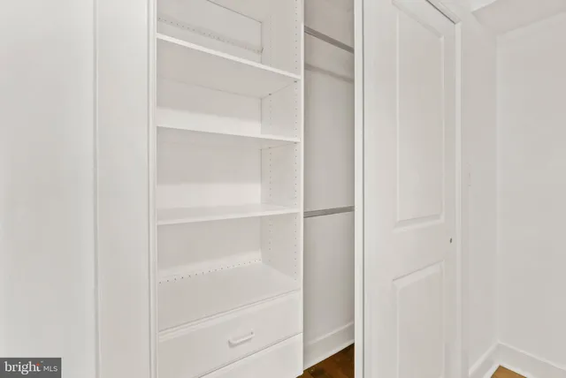 a view of walk in closet with empty racks
