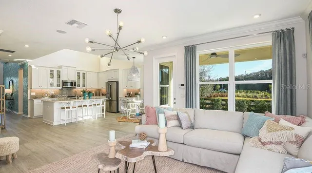 a living room with furniture a chandelier and a view