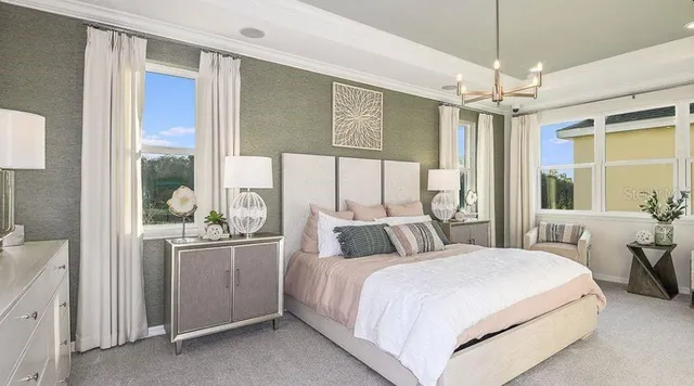 a bedroom with a large bed and a chandelier