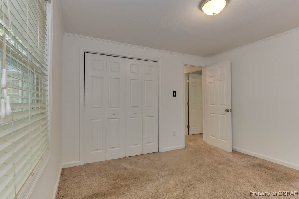 8729 Marlfield Road Gloucester, VA 23061 - Photo 21 of 32 Unfurnished bedroom with crown molding, light colored carpet, and a closet