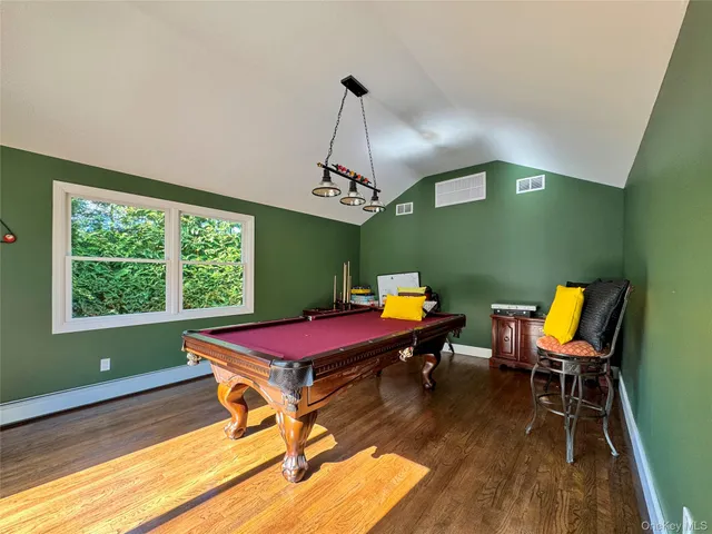 a room with pool table windows and wooden floor