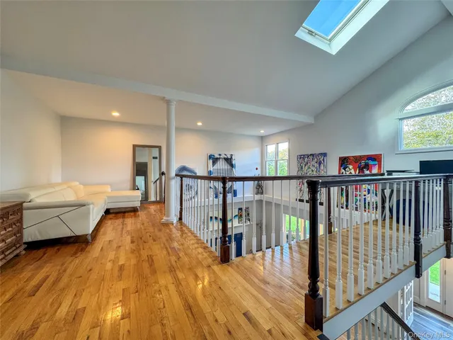 a view of a hallway with wooden floor and stairs