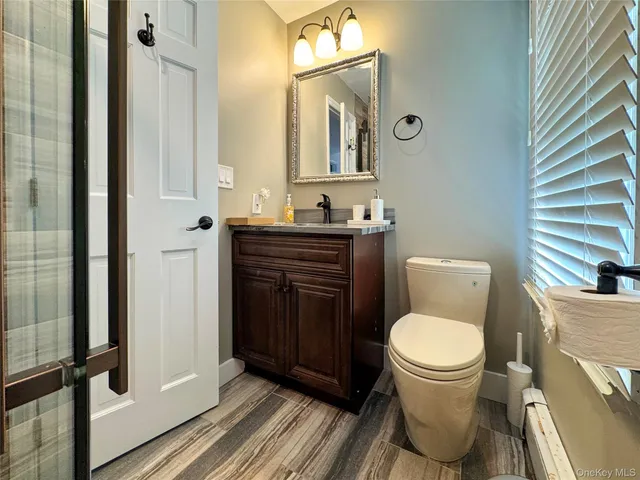 a bathroom with a toilet a sink and mirror