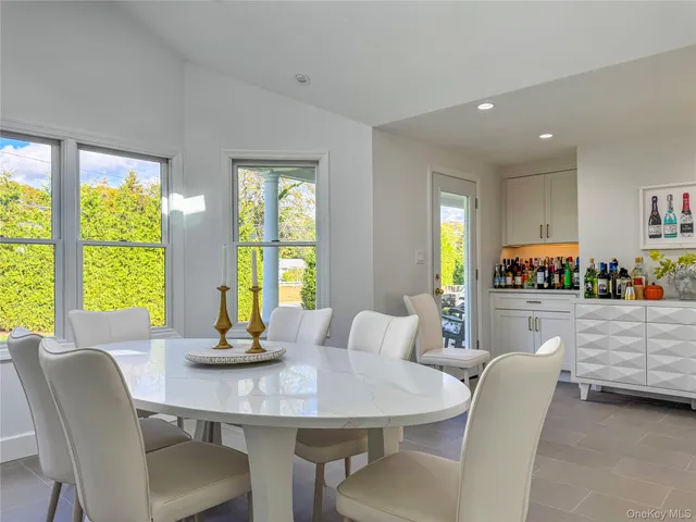 a dining room with furniture a large window and a chandelier