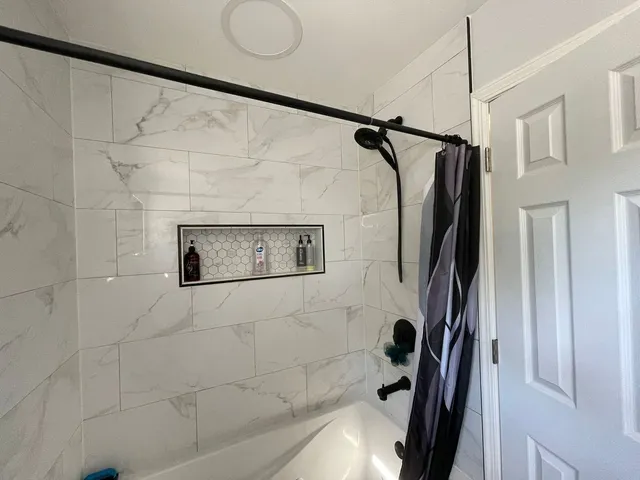 a bathroom with a shower and a glass door