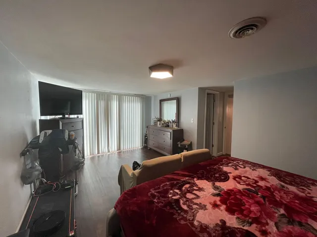 a bedroom with a bed and a flat tv screen on wall