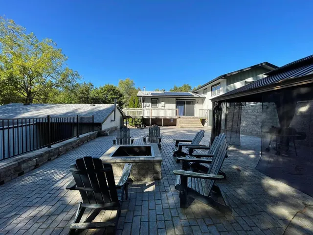 a view of a patio with table and chairs with wooden floor and fence
