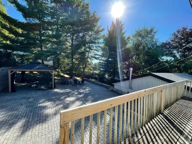 a view of a roof deck with couches and wooden fence