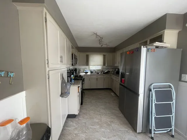 a kitchen with a refrigerator and cabinets