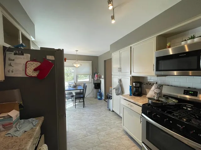 a kitchen with stainless steel appliances granite countertop a stove top oven a sink dishwasher and a microwave oven on the blue kitchen countertops