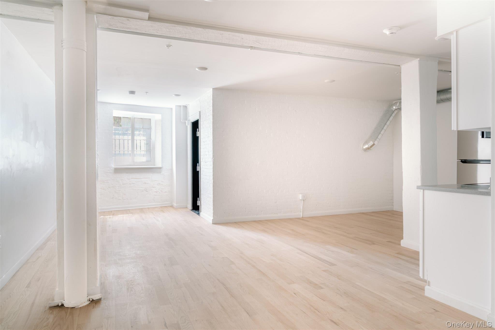 155 River Street, Unit BASEMENT C Troy, NY 12180 - Photo 7 of 22 a view of an empty room with wooden floor and a window