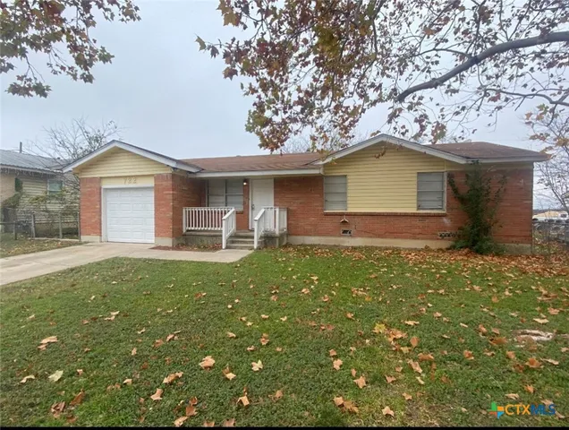 a front view of a house with a garden and yard