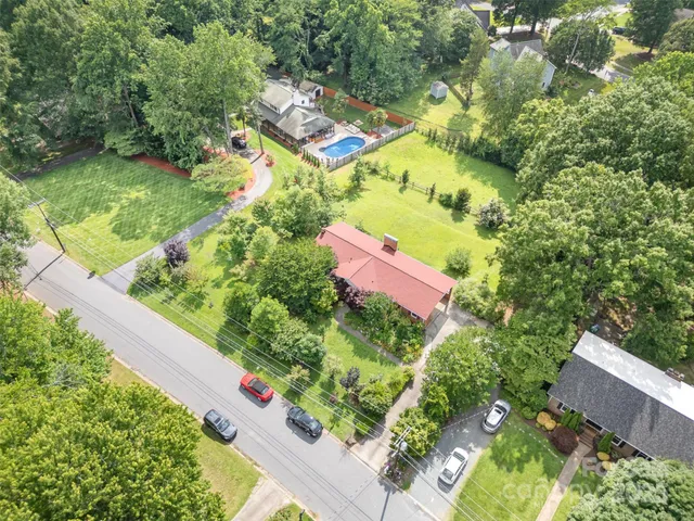an aerial view of residential house with outdoor space and trees all around