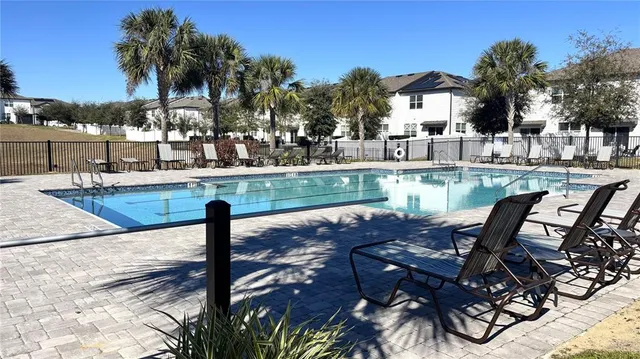 a view of a swimming pool with chairs and tables