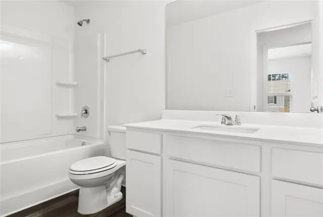 a bathroom with a toilet sink vanity tub and shower