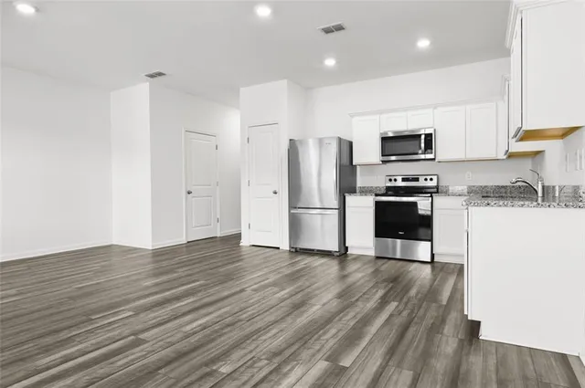 a kitchen with stainless steel appliances a refrigerator and a stove top oven