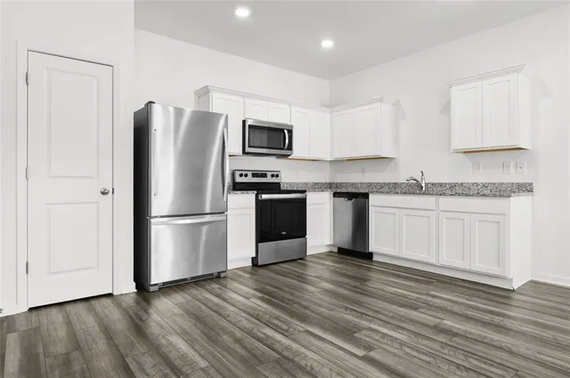 a kitchen with stainless steel appliances a refrigerator sink and cabinets