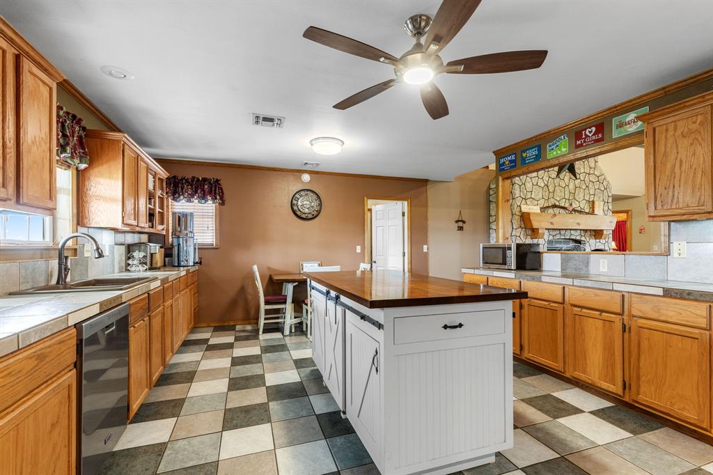 13315 Highway 281 Scotland, TX 76379 - Photo 10 of 40 Spacious kitchen with a central custom island, light wood cabinetry, and a checkerboard tile floor