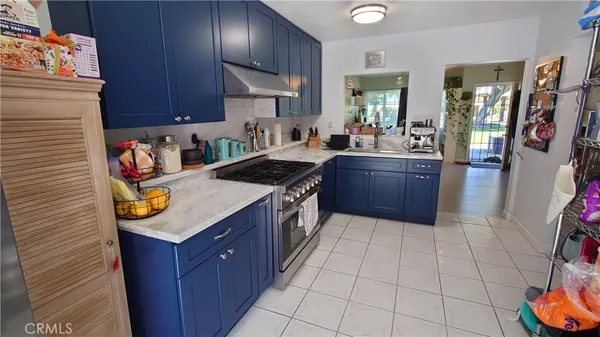 a kitchen with stainless steel appliances granite countertop a stove a sink and a refrigerator