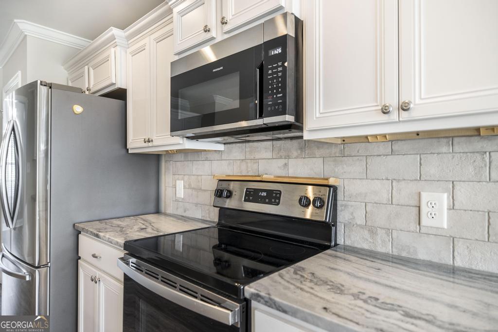 216 Georgian Walk Byron, GA 31008 - Photo 15 of 37 a kitchen with stainless steel appliances white cabinets and a stove top oven