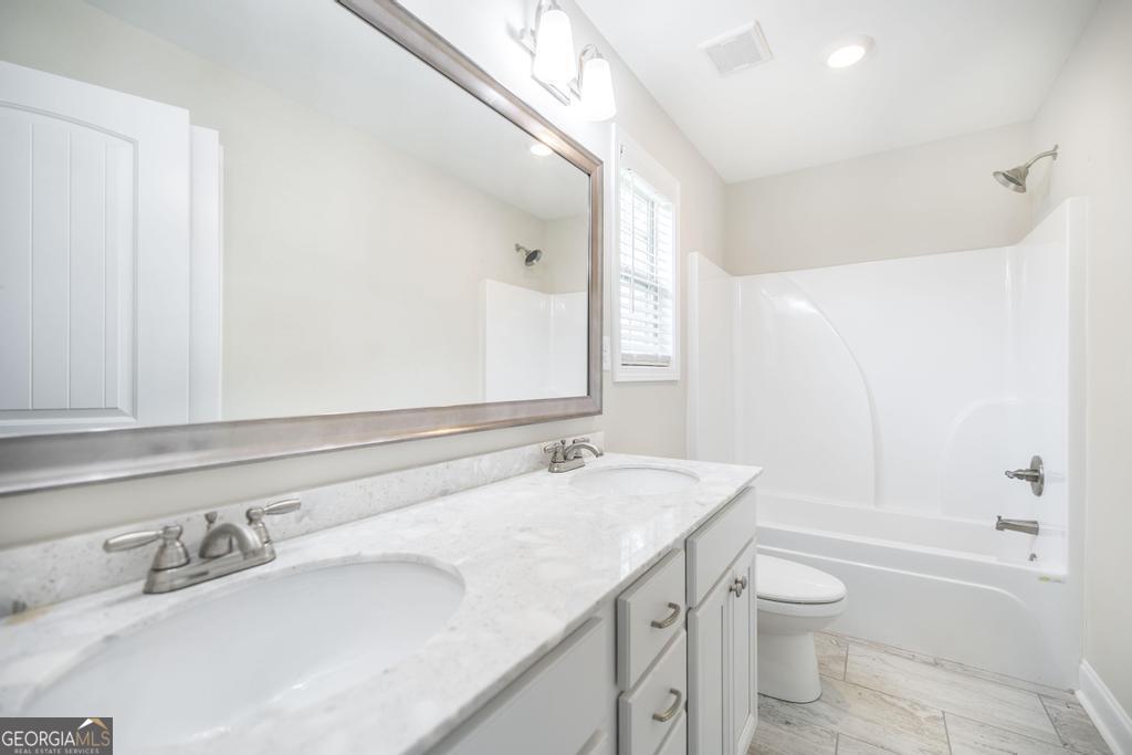 216 Georgian Walk Byron, GA 31008 - Photo 20 of 37 a bathroom with a granite countertop sink toilet and shower