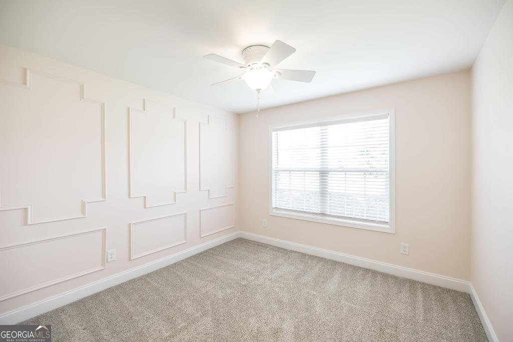 216 Georgian Walk Byron, GA 31008 - Photo 23 of 37 an empty room with chandelier fan and windows