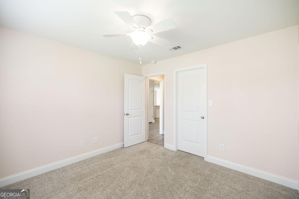 216 Georgian Walk Byron, GA 31008 - Photo 24 of 37 an empty room with a ceiling fan and a window