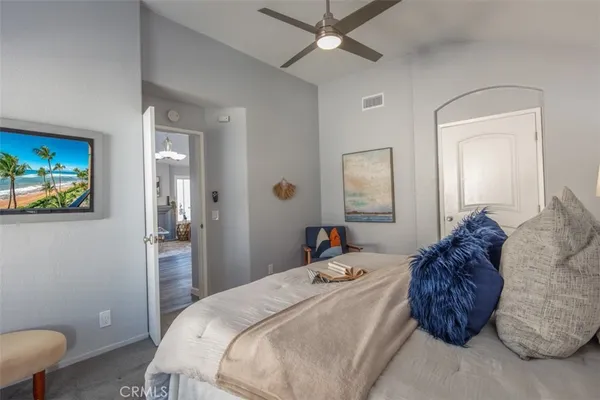 a large bed sitting in a bedroom next to a lamp