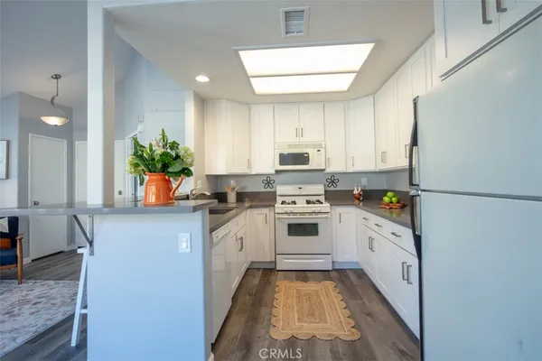 a kitchen with granite countertop white cabinets and white stove