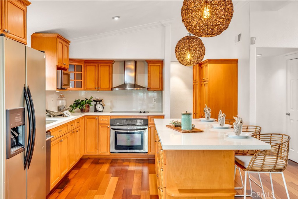 1724 El Rey Road San Pedro, CA 90732 - Photo 12 of 51 a kitchen with stainless steel appliances granite countertop a sink a stove a oven a dining table and chairs with wooden floor