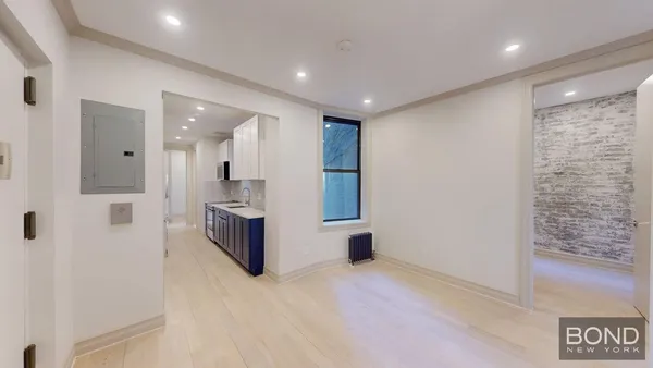 a view of a hallway with stainless steel appliances kitchen island