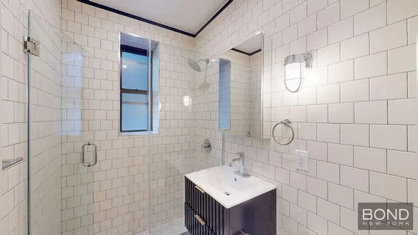 a bathroom with a shower sink and mirror