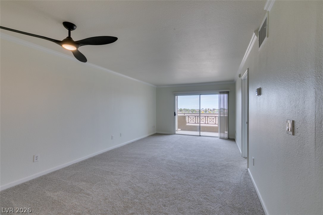 8070 West Russell Road, Unit 2026 Las Vegas, NV 89113 - Photo 12 of 41 A spacious room offers comfortable carpet flooring and a glass slider opening to a private balcony.