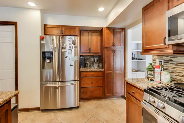 a kitchen with stainless steel appliances granite countertop a refrigerator stove and cabinets
